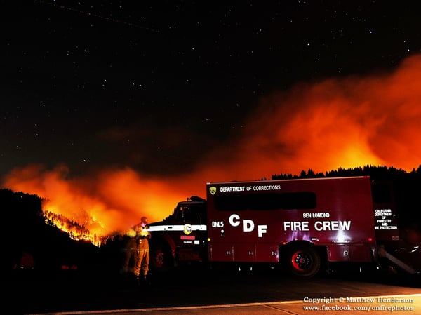 A Cal Fire firefighter checks his cell-phone from atop the helipad overlooking the King Fire.